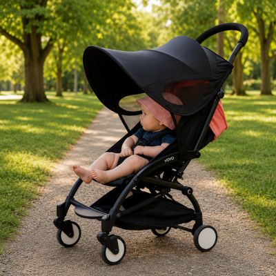 bébé avec chapeau rose assis dans poussette avec pare soleil poussette au parc