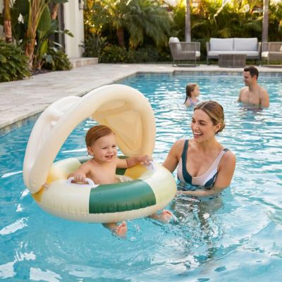 bébé joyeux dans bouée bebe dans piscine de hotel avec maman et famille