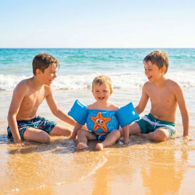 bébé avec brassard flottant assis sur rivage avec ses grands frères en vacances