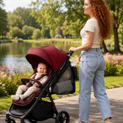 organisateur de poussette accroché à une poussette poussé par maman rousse promenant bébé au bord du lac