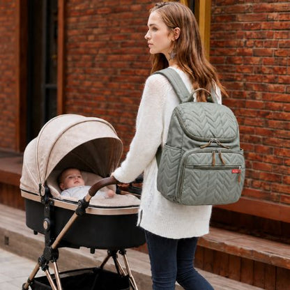 sac a dos a langer porté par jeune maman marchant en ville avec bébé dans poussette