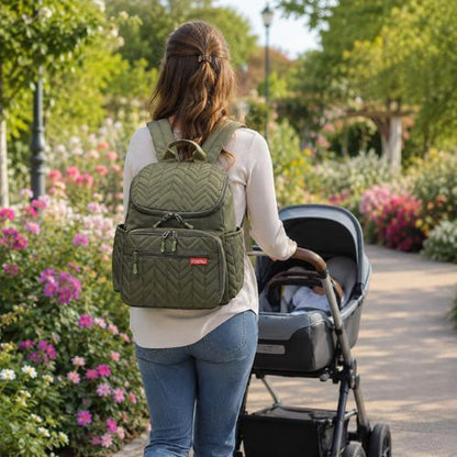 sac a dos a langer au dos d'une maman promenant bébé au parc dans poussette