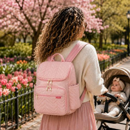 sac a dos a langer porté par maman promenant bébé dans poussette au parc avec belles tulipes