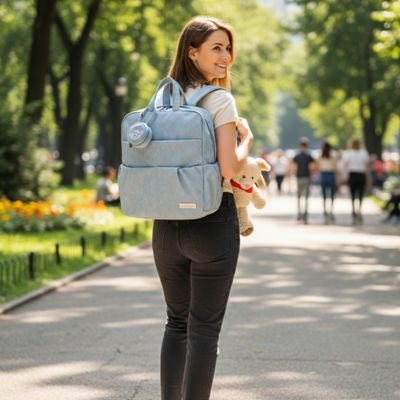 maman portant sac à langer sac à dos en marchant dans un beau parc