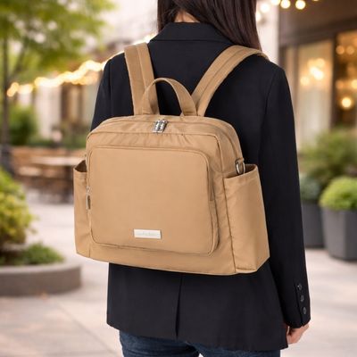 femme élégante portant sac a dos a langer à son dos devant un restaurant