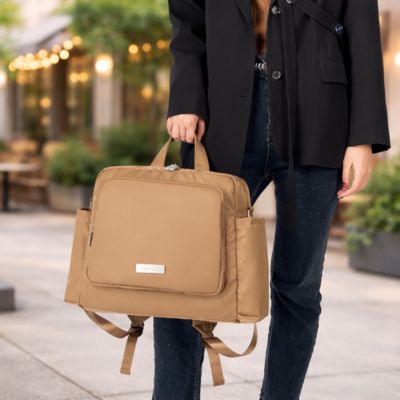 sac a dos a langer porté par maman élégante par les poignées