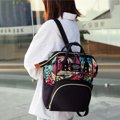 sac a dos a langer porté par maman par une bretelle