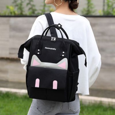 sac a dos a langer catlyn noir porté par maman sur épaule