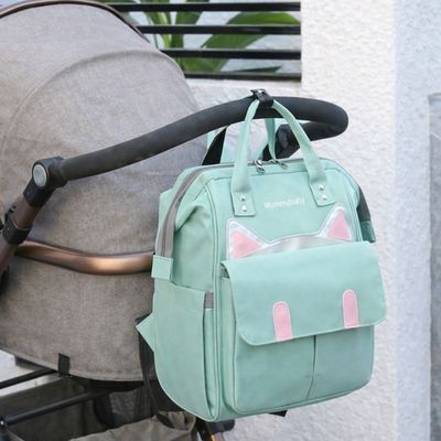 sac a dos a langer catlyn vert accroché à poussette