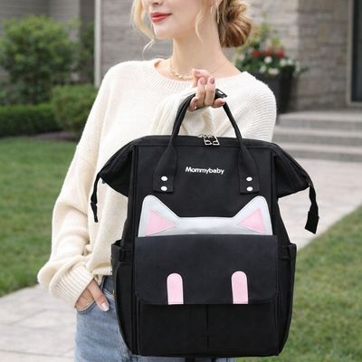 maman portant sac a dos a langer par les manches