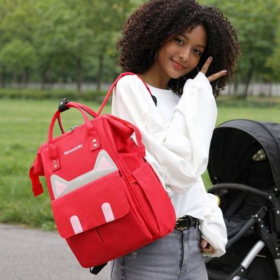 maman jeune portant sac a dos a lange sur épaule dans parc