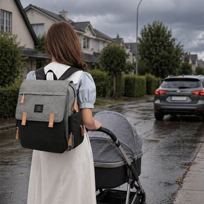 sac a dos a langer imperméable porté par maman poussant poussette 