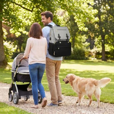 sac a dos à langer porté par papa entrain de se promener au parc avec bébé et maman