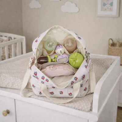 sac a langer bebe avec accessoires pour bébé dedans posé sur table à langer 