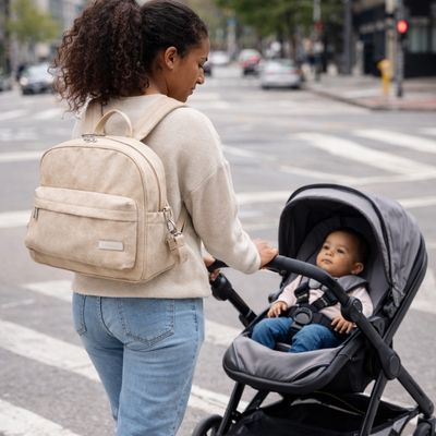 sac à langer sac à dos porté par maman traversant une rue en poussant bébé dans poussette